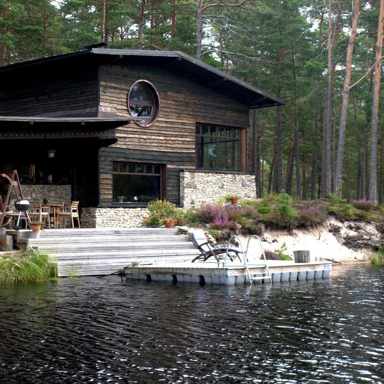 a log cabin with a dock in the water at Samblamaa Guesthouse in Rannaküla