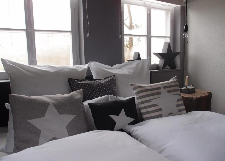 ein Bett mit schwarzen und weißen Kissen und Sternen darauf in der Unterkunft Ferienhaus Loft in der alten Schreinerei in Billingsbach