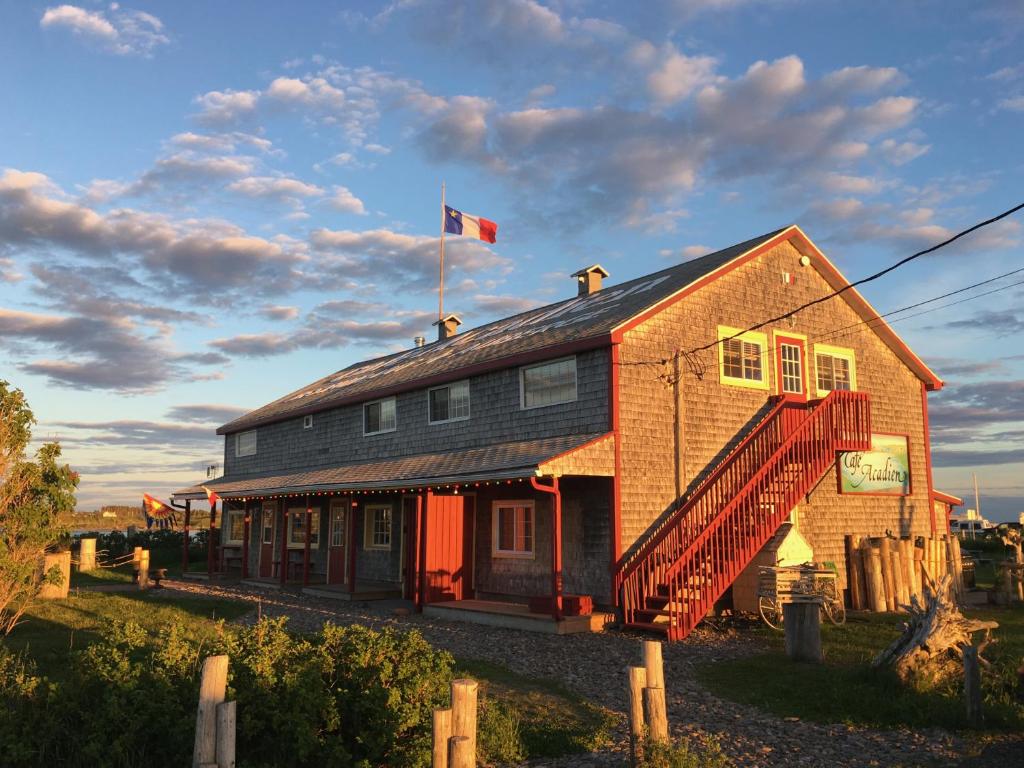 a house with a flag on top of it at Auberge Café Acadien in Bonaventure