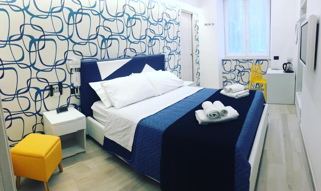 ナポリにあるSTARITA BED & PIZZAのベッドルーム(青と白のベッド1台、黄色の椅子付)