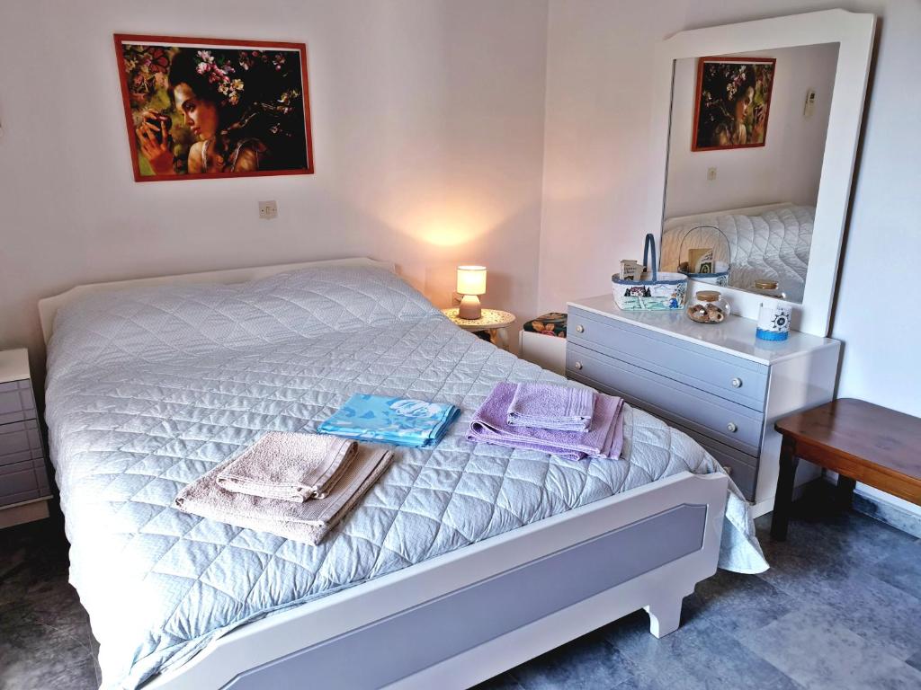 a bedroom with a white bed and a mirror at Myrto's Apartment No15 in Loutra Oraias Elenis