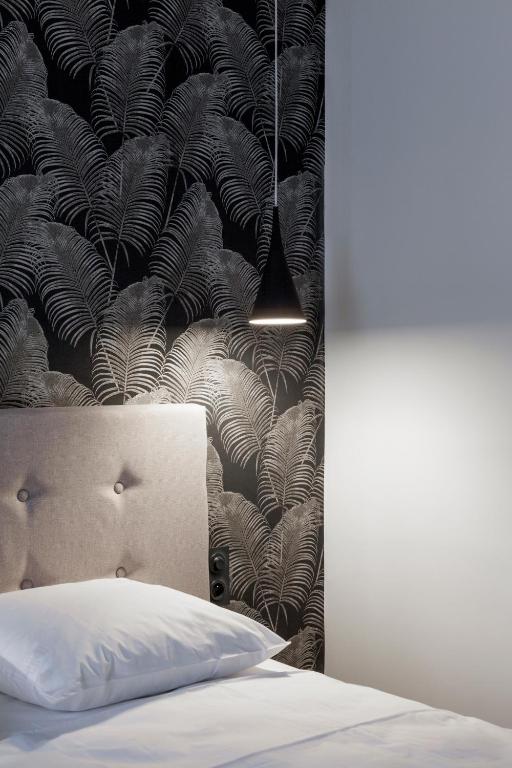 - une chambre avec un lit et du papier peint noir et blanc dans l'établissement Logis Hotel du Maine, à Laval