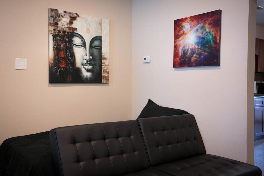 a living room with a couch and three paintings on the wall at East Downtown Treetop Terrace in Houston