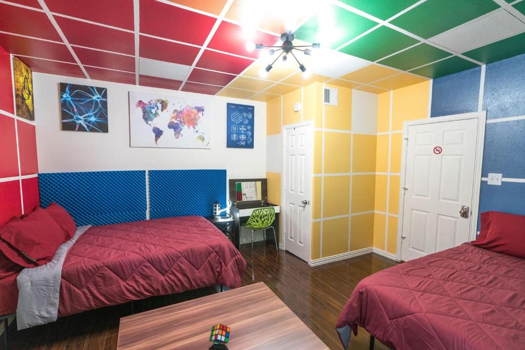 East Downtown Rubiks Studio في هيوستن: غرفة ملونة مع سريرين وطاولة