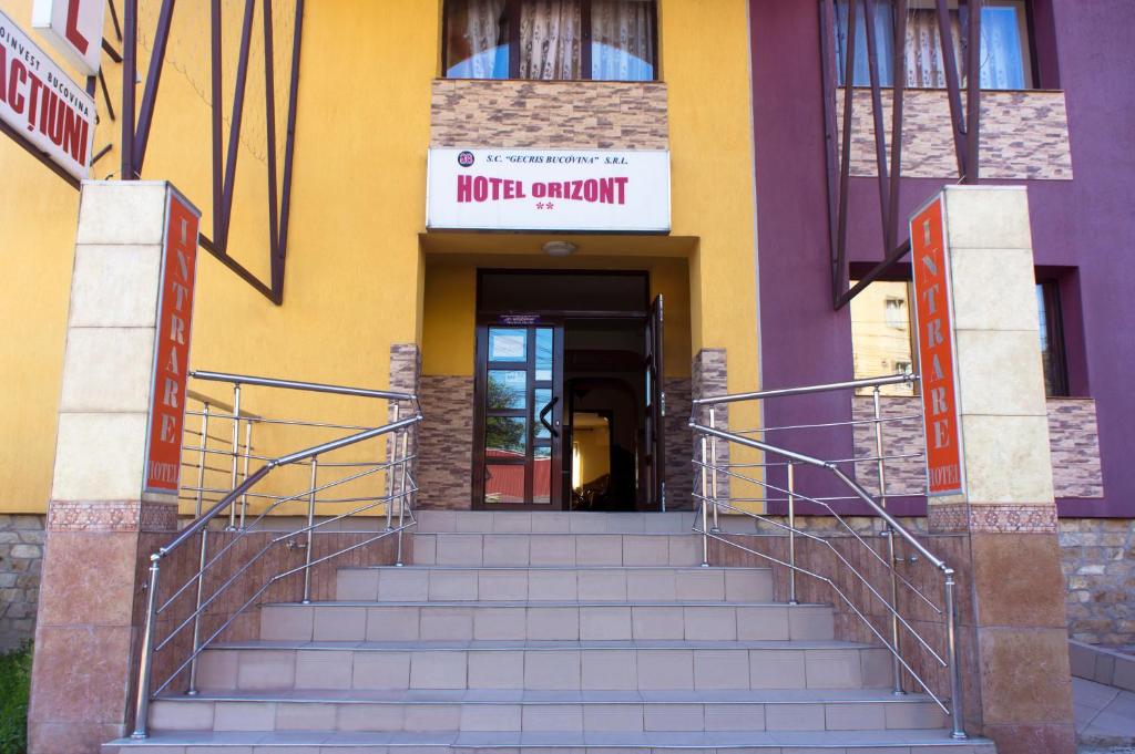 un escalier menant à un bâtiment avec une entrée. dans l'établissement Hotel Orizont Suceava, à Suceava