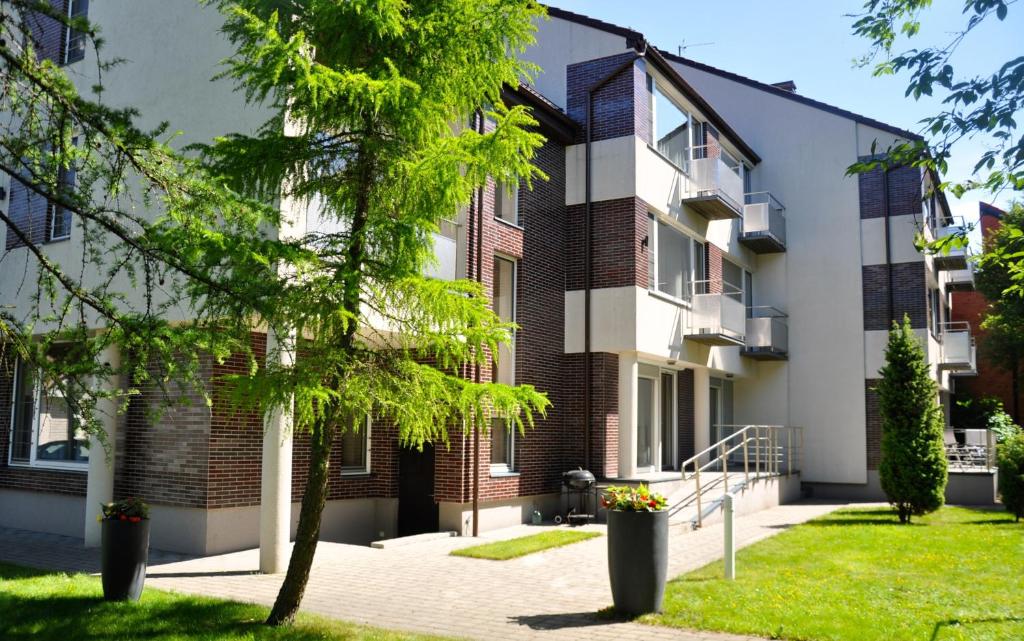 an apartment building with a tree in the courtyard at Sancta Elena in Šventoji