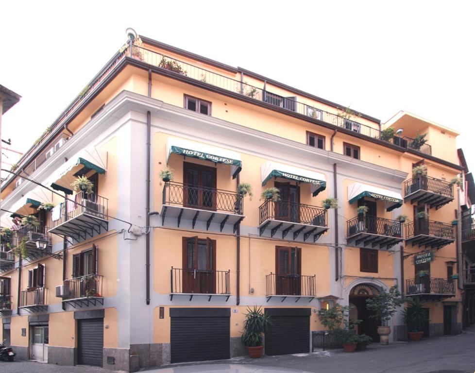 un gran edificio con balcones y plantas. en Hotel Cortese en Palermo