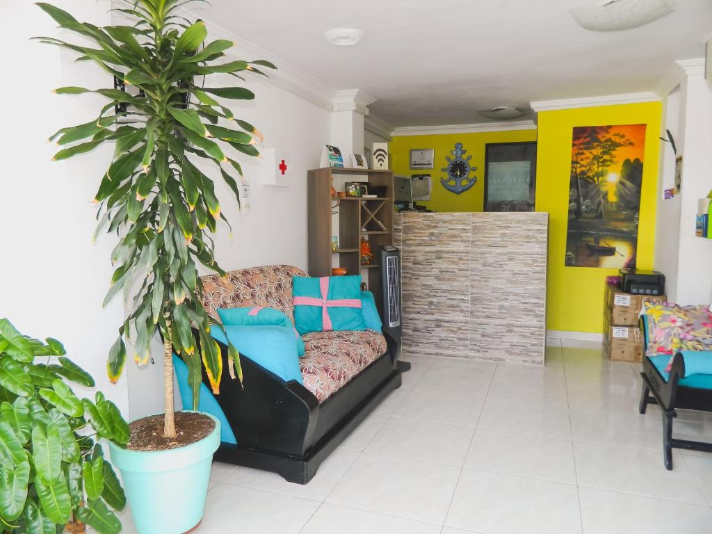 Una sala de estar con un sofá y una planta. en Hostel Stingray, en San Andrés