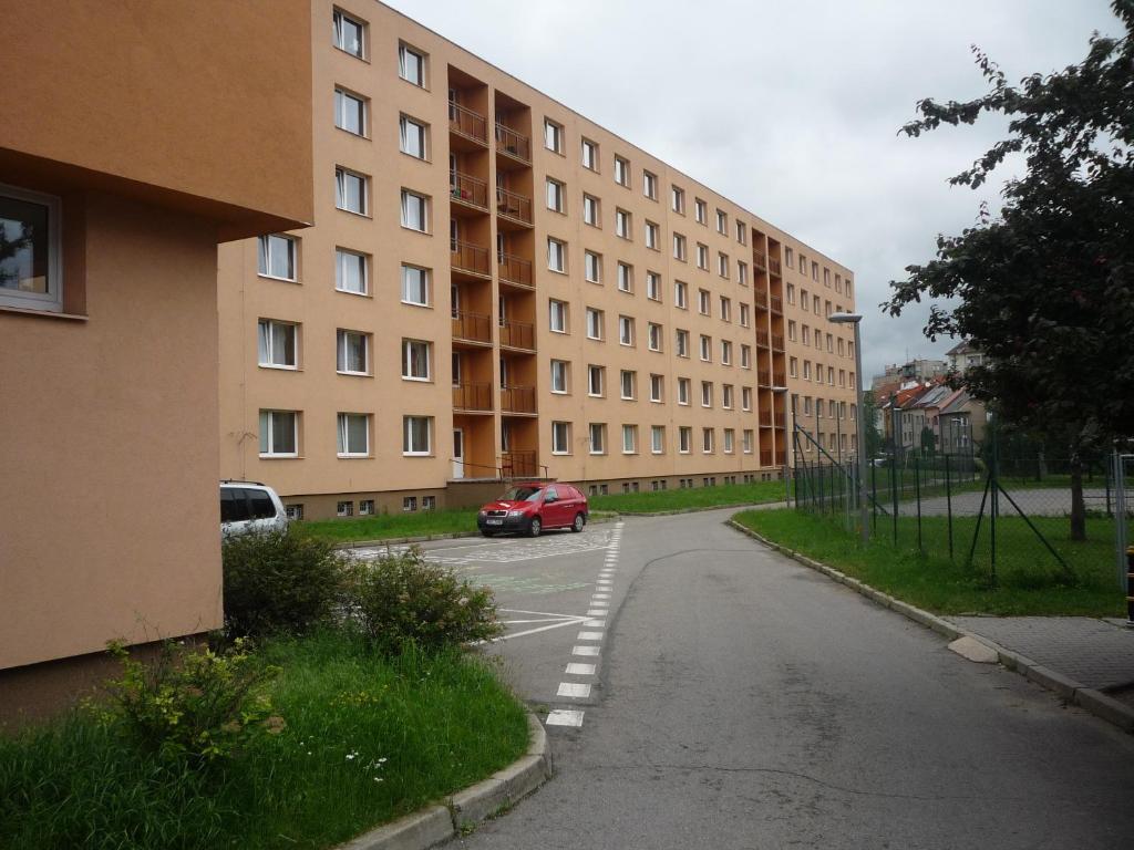 um carro vermelho está estacionado em frente a um edifício em Koleje J.A.Komenského em Brno