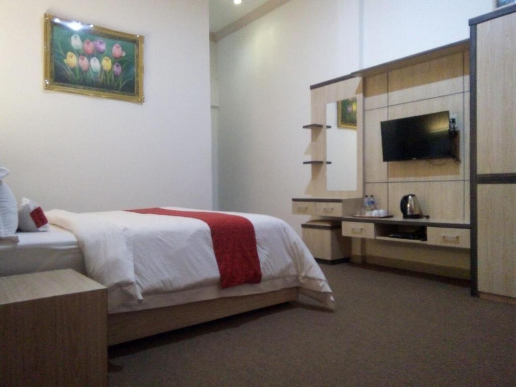 a hotel room with a bed and a television at Hotel Assyifa Tanjungbalai in Tanjungbalai