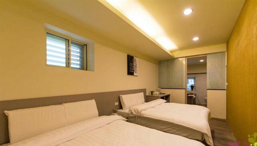 a bedroom with two beds and a window at YY Elleys Home in Jiaoxi