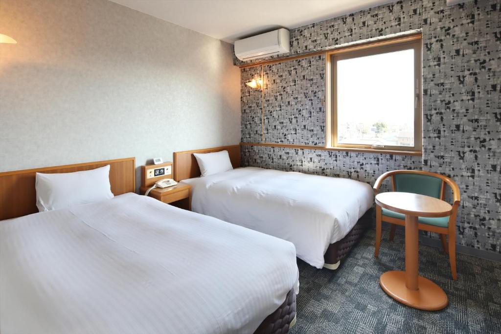 Habitación de hotel con 2 camas y ventana en Green Rich Hotel Aso Kumamoto Airport (Artificial hot spring Futamata Yunohana), en Kikuchi