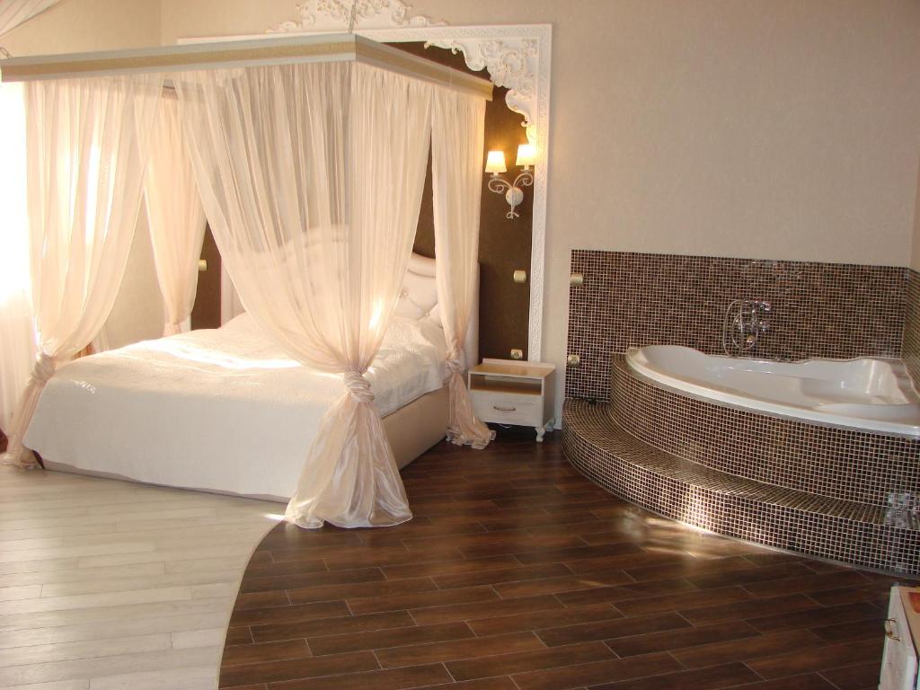 a bedroom with a bed and a bath tub at Knyazhyi Dvir in Sokilnyky