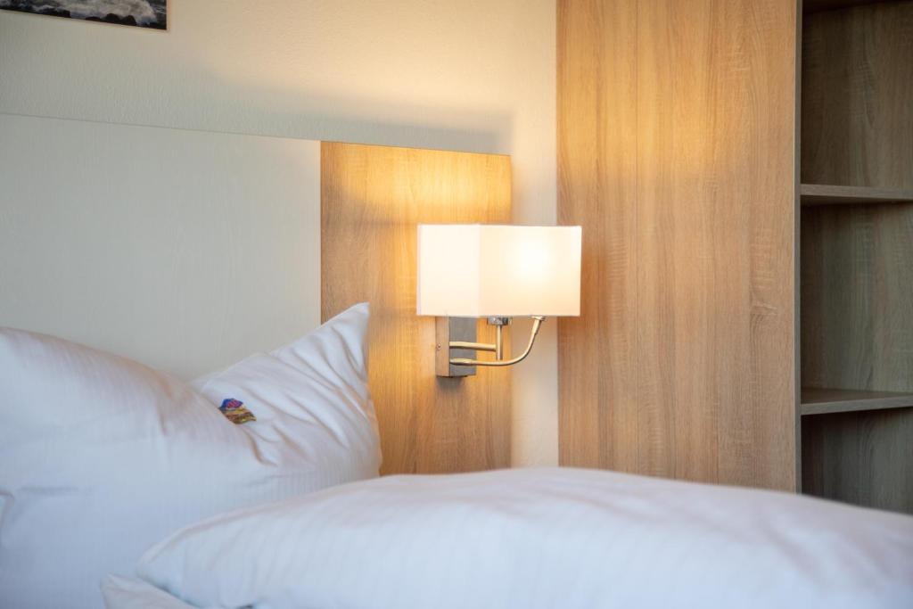 Postel nebo postele na pokoji v ubytování Heeren's Hotel Garni
