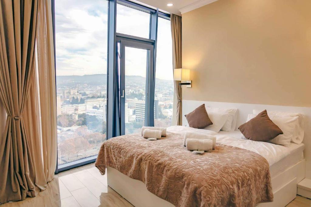 a bedroom with a bed with a large window at King David Residence in Tbilisi City