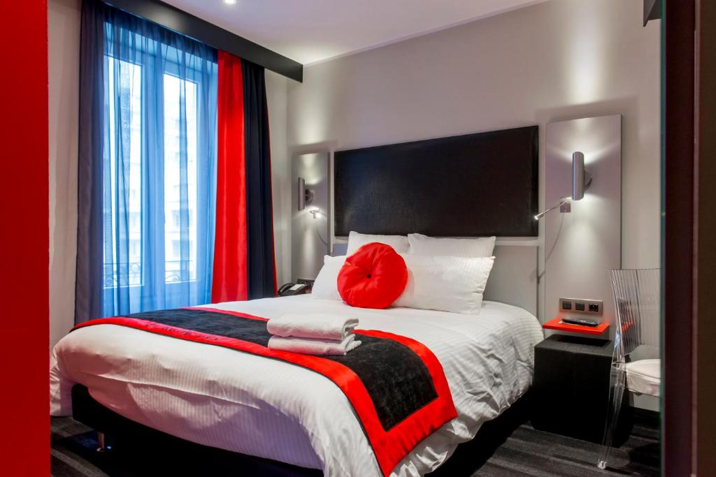 Un dormitorio con una cama grande con una almohada roja. en Hôtel Boutique Richelieu, Lyon Gare Part-Dieu, en Lyon