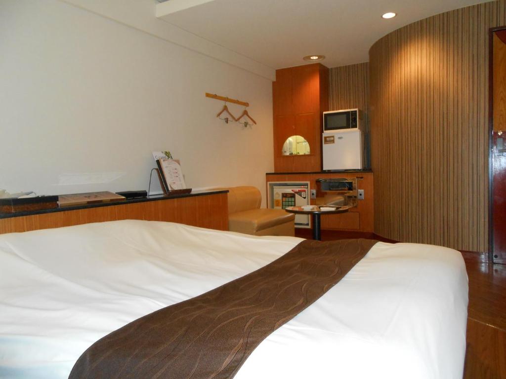 une chambre d'hôtel avec un lit et une cuisine dans l'établissement Hotel Lumiere Gotenba (Adult Only), à Gotemba