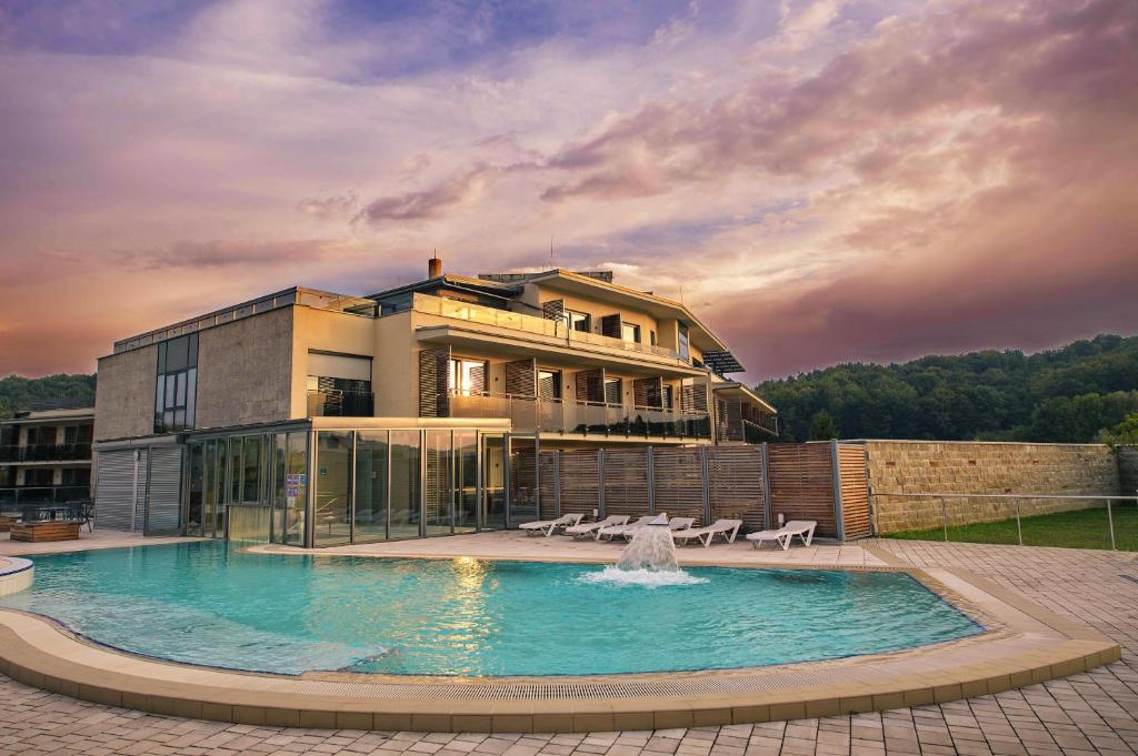 un edificio con una gran piscina frente a una casa en HOTEL Bioterme Mala Nedelja, en Ljutomer