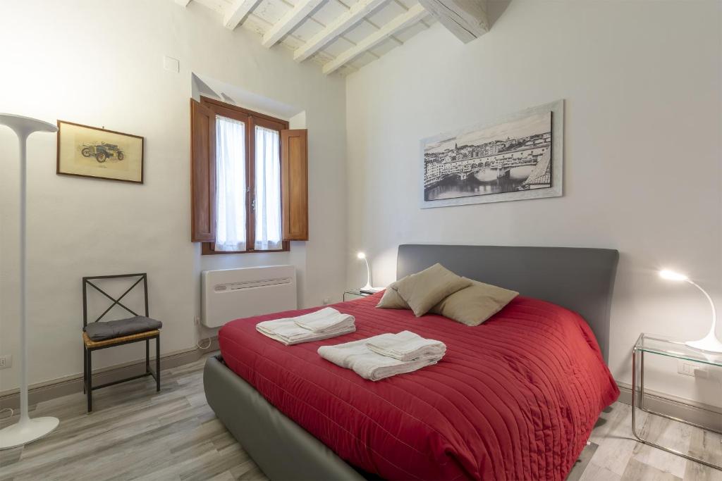 フィレンツェにあるPonte Vecchio's Nestのベッドルーム1室(赤いベッド1台、タオル2枚付)