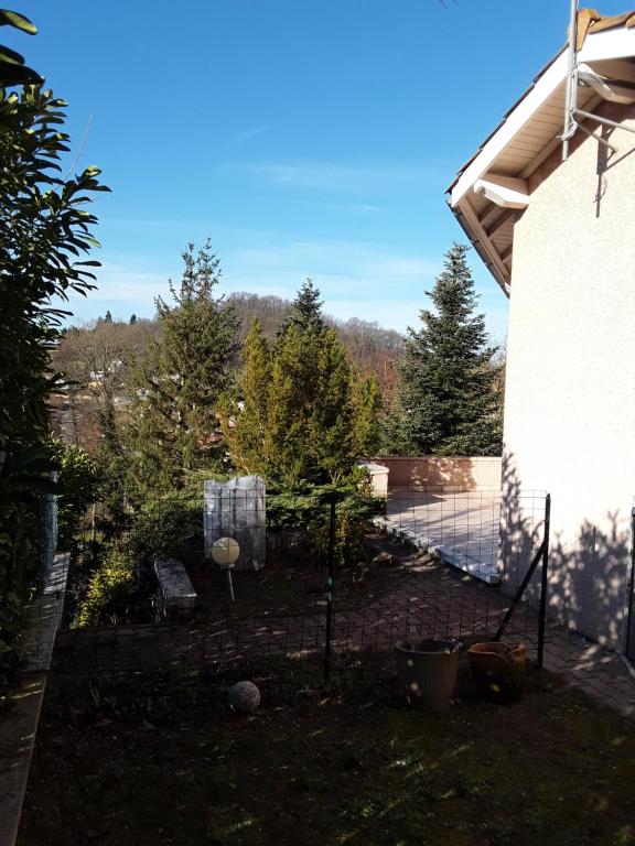 vistas a un patio trasero con una valla y árboles en Villas en chanay, en Dagneux