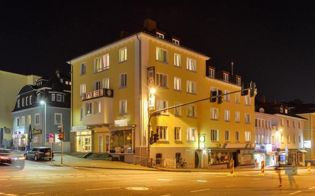 a large yellow building on a city street at night at Liebig-Hotel in Gießen