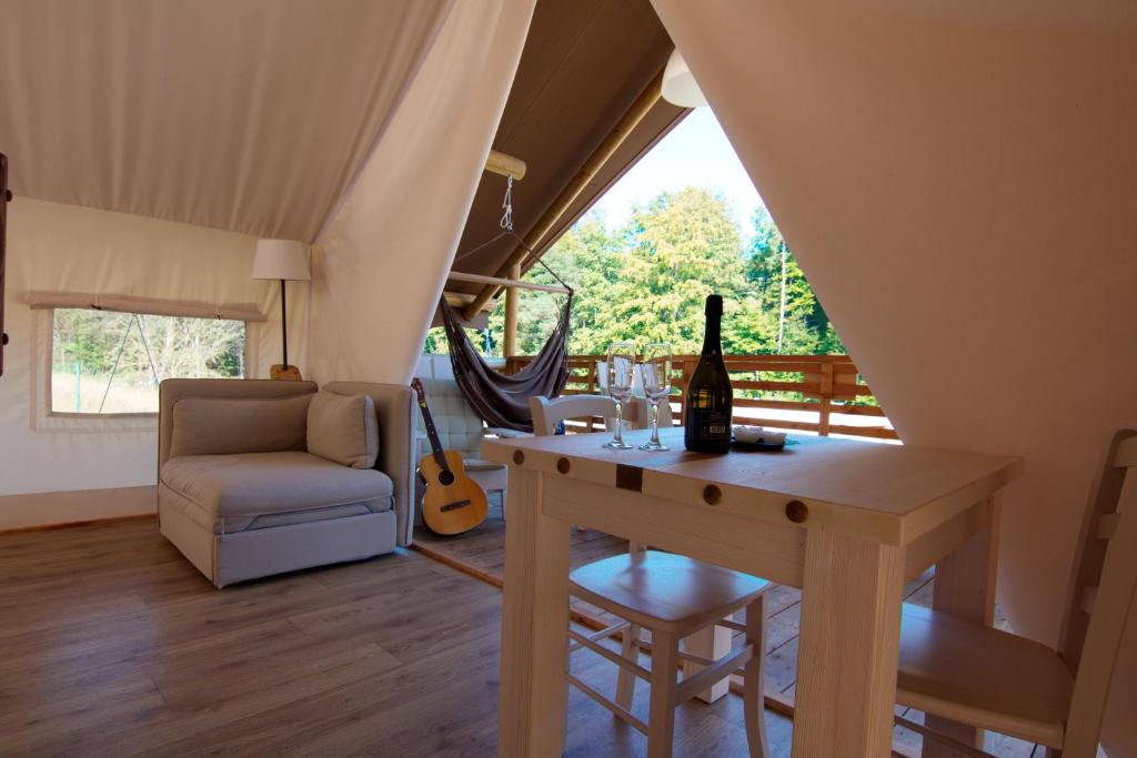 a room with a table with a bottle of wine at Glamping SUN VALLEY Bioterme in Mala Nedelja