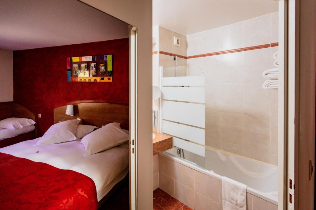 een slaapkamer met een bed en een bad bij Kyriad Nîmes Ouest A9 in Nîmes