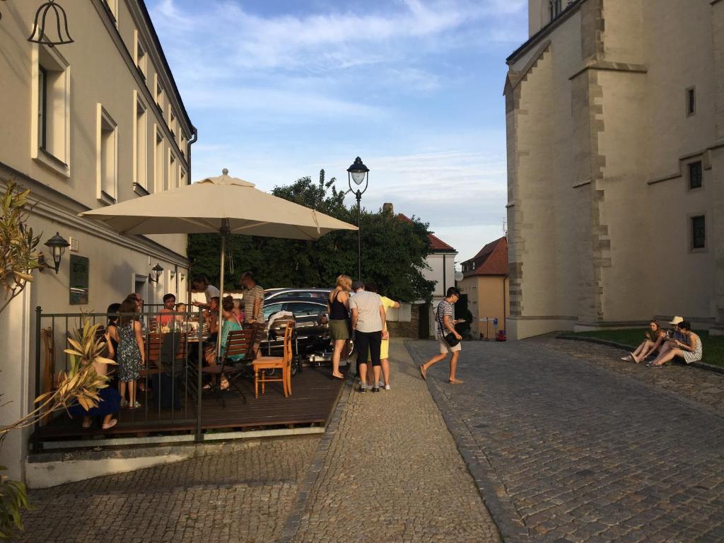 eine Gruppe von Menschen, die mit einem Regenschirm an einem Tisch sitzen in der Unterkunft Rezidence Zvon in Znojmo