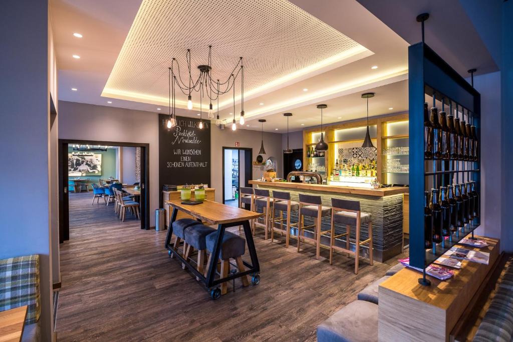 un bar dans un restaurant avec une table et des chaises dans l'établissement Parkhotel Nordwalde, à Nordwalde