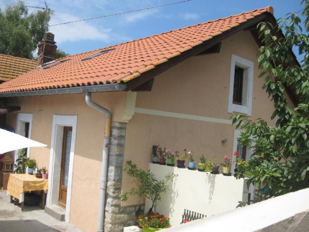 una casa con techo rojo y plantas en una valla en karine, en Boucau