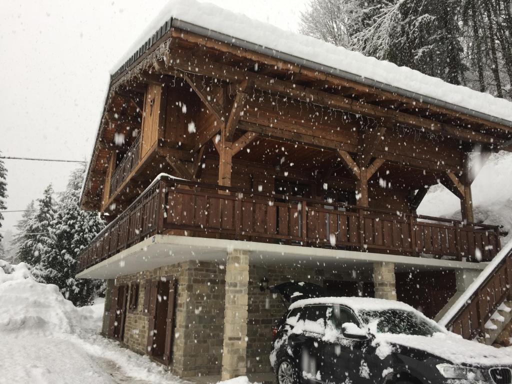 una casa con un coche aparcado en la nieve en Arbroz en La Côte dʼArbroz