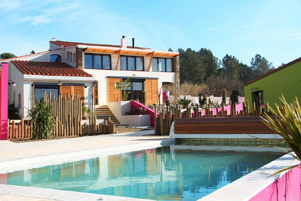 una casa con piscina frente a una casa en ASINERIE KULENI en Ponteilla