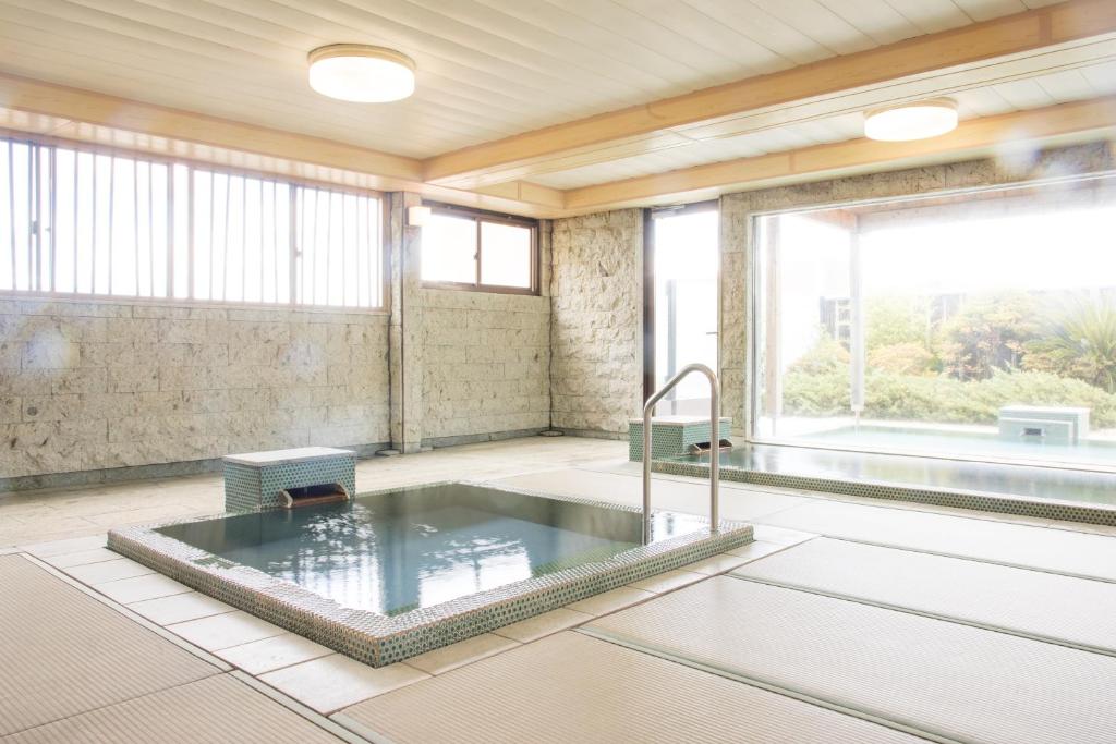 a large bathroom with a tub and a large window at Yoshino in Ito