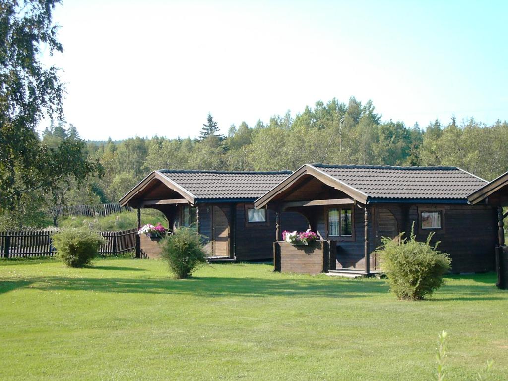 a house in a field with some plants in the yard at Camping stuga fyra bäddar in Fagersta