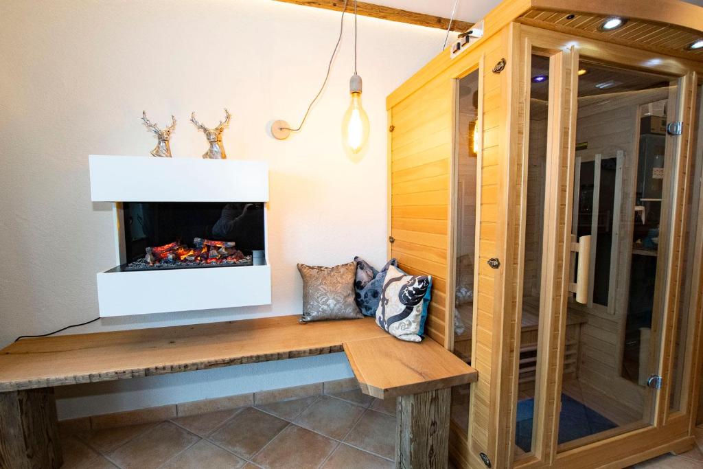 a bench in a room with a fireplace at Alp-Chalet in Hirschegg