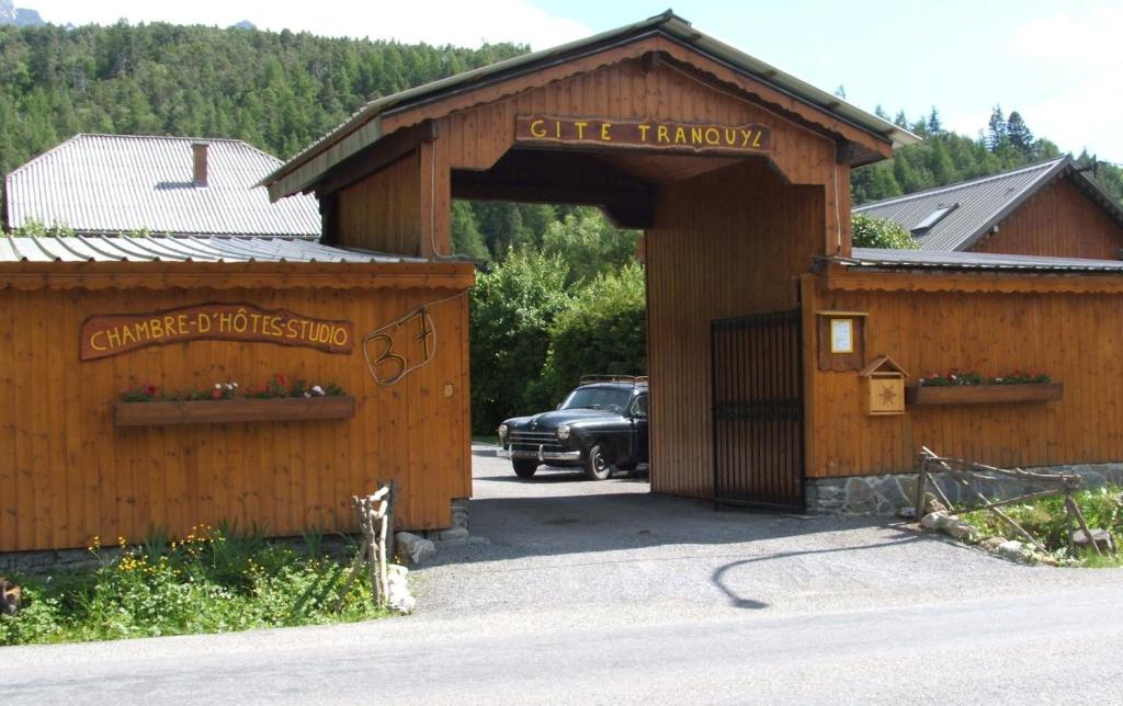 a building with a car parked in a parking lot at Maison d' hôtes Tranquyl in Barcelonnette