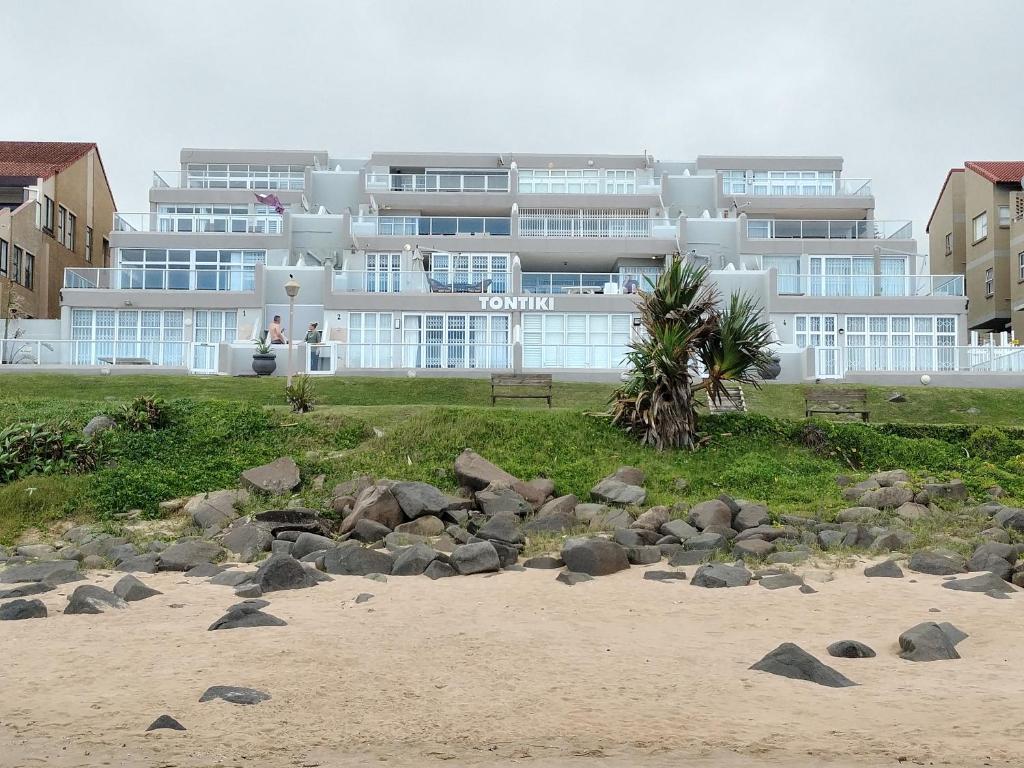 a building on the beach with rocks in front of it at 19 Tontiki in Ballito