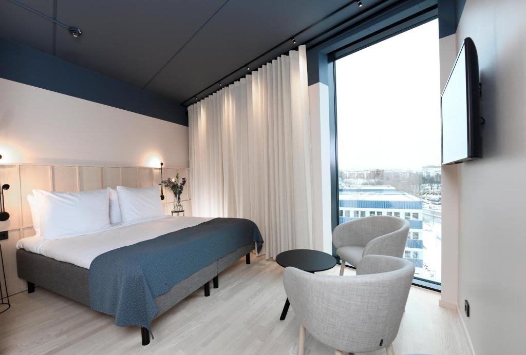 a hotel room with a bed and a large window at Best Western Plus Grow Hotel in Solna