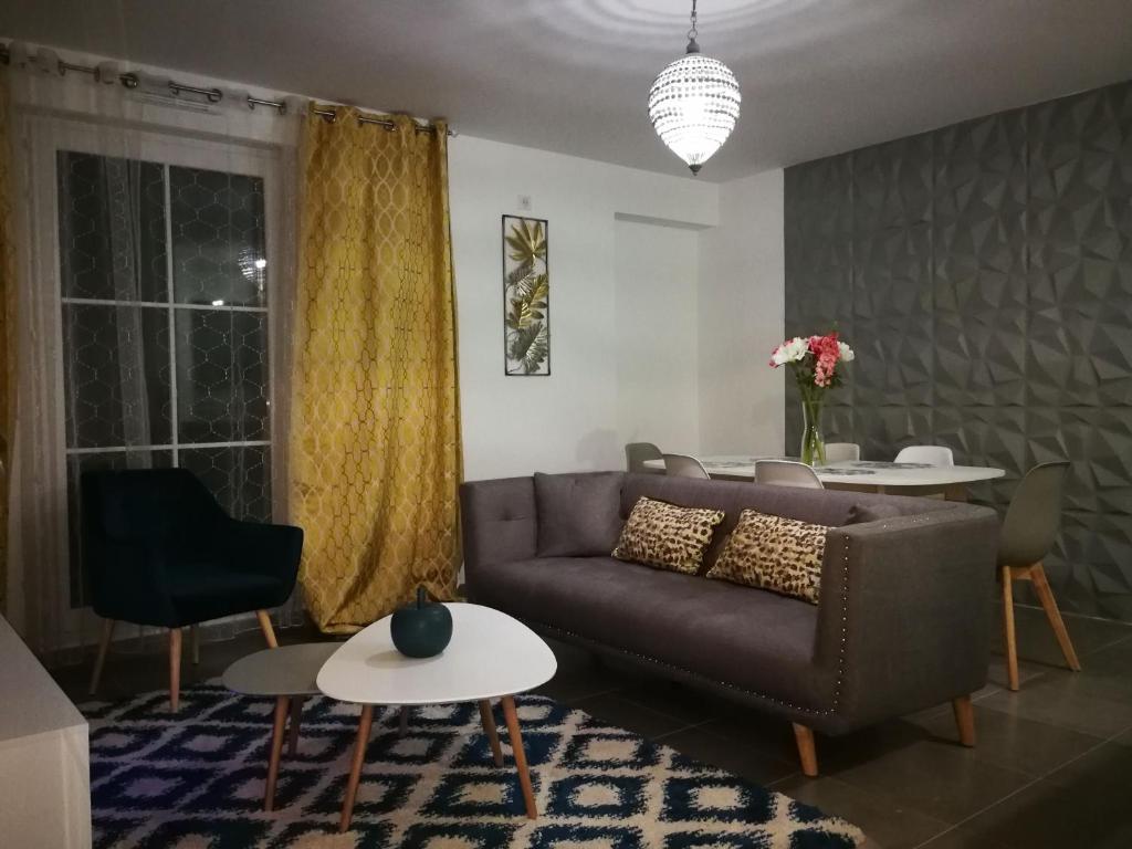 uma sala de estar com um sofá e uma mesa em New and Luxury apartment Disneyland Paris em Serris