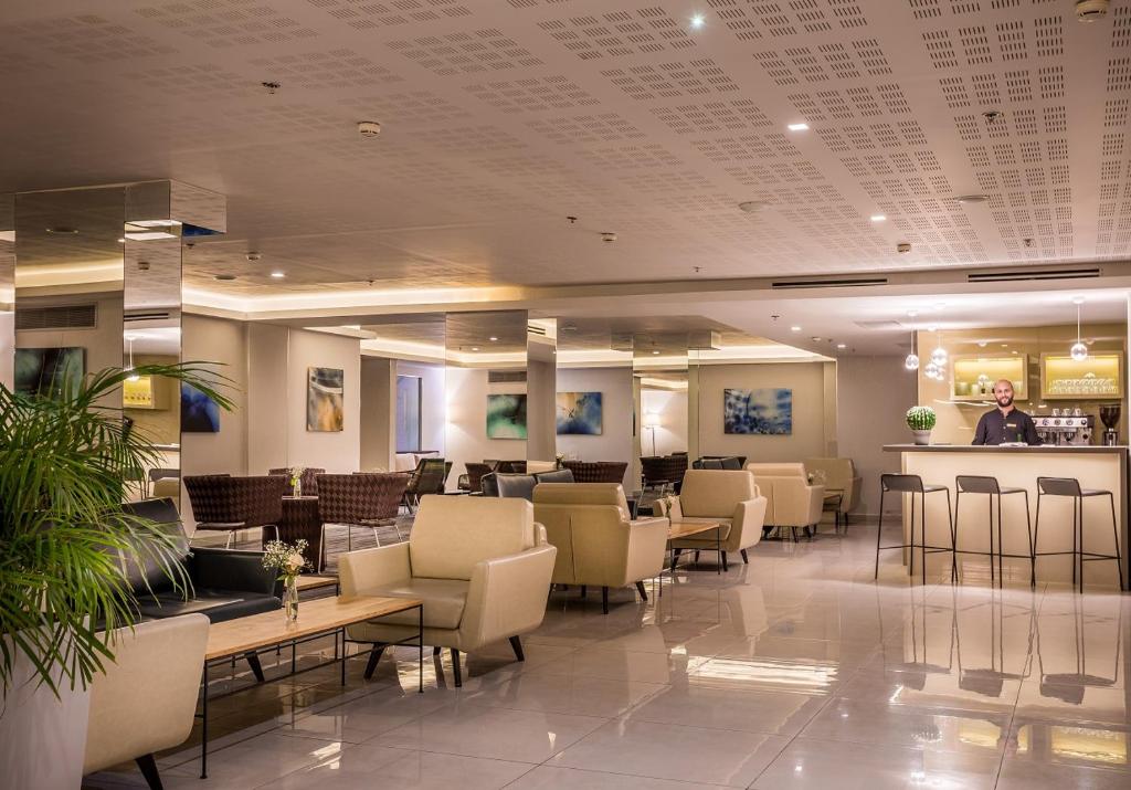 eine Lobby mit einem Wartezimmer mit Stühlen und einer Bar in der Unterkunft Hotel Astral Nirvana Club- Half Board in Eilat