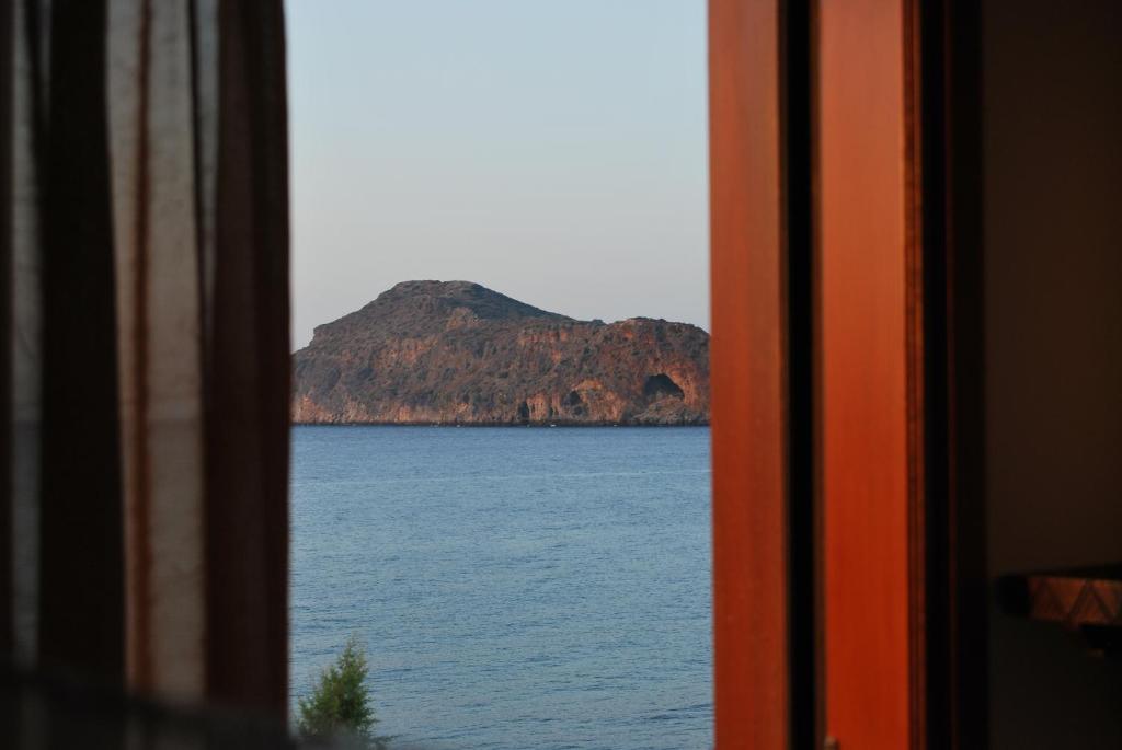 a view of a large body of water from a window at Vasiliki Apartments in Plataniás