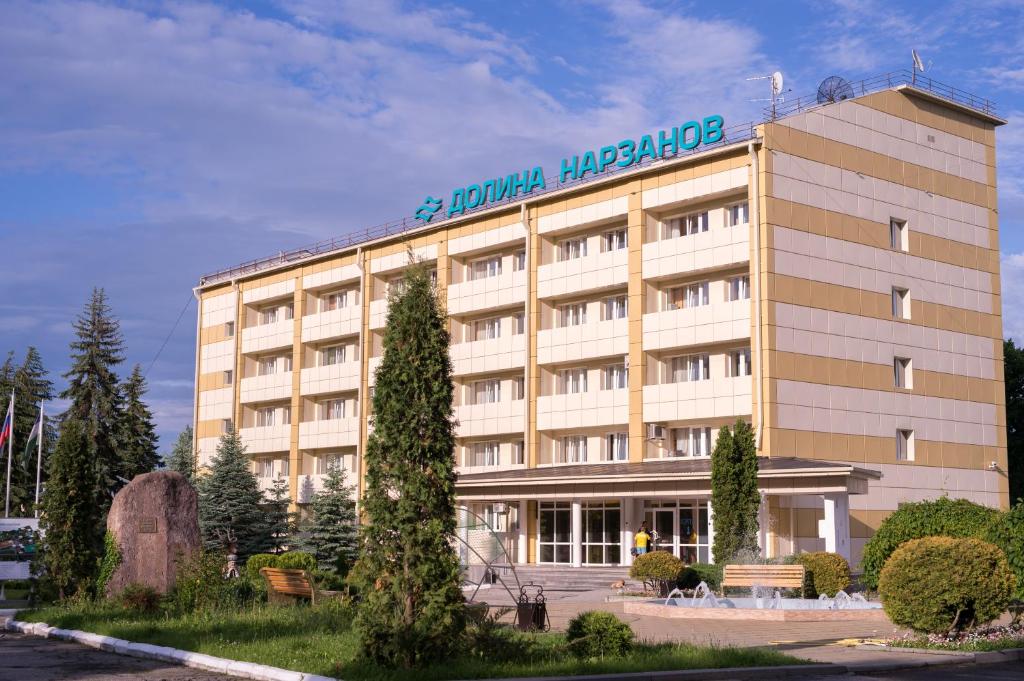Health Resort Dolina Narzanov Nalchik في نالتشيك: مبنى الفندق يوجد عليه لافته
