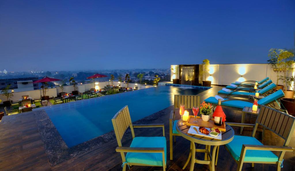 阿格拉的住宿－Hotel Royale Regent，酒店屋顶设有游泳池、桌子和椅子