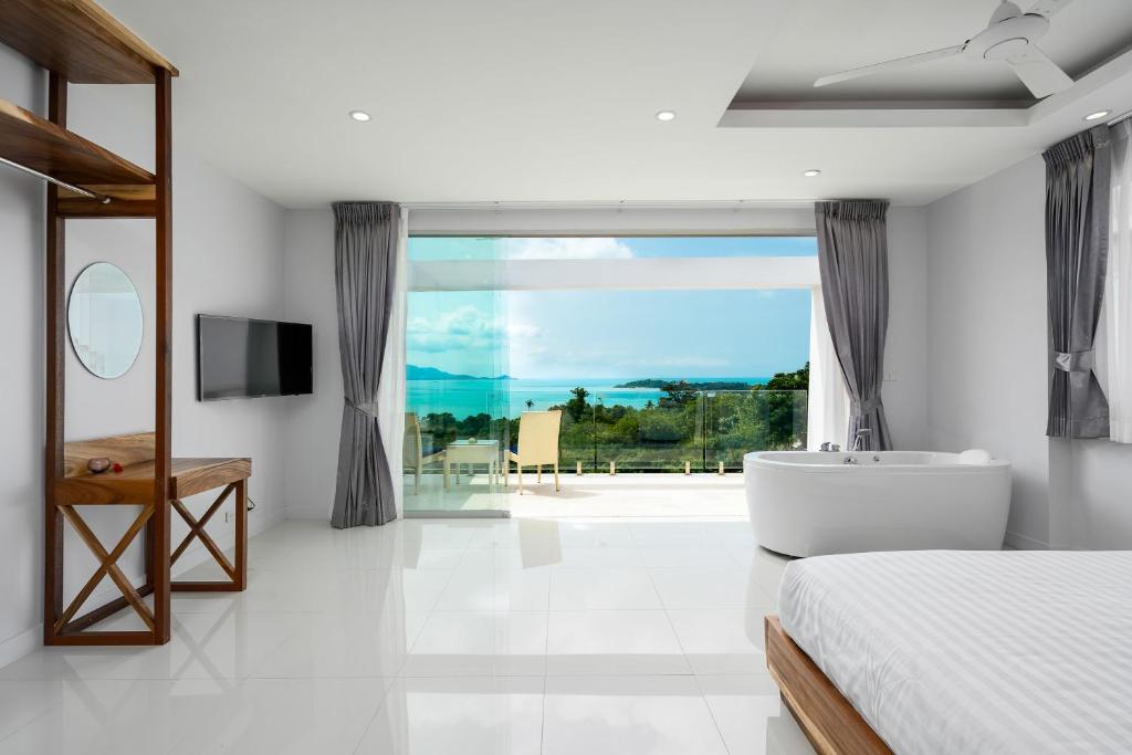 a bedroom with a bed and a tub and a window at Sunset Lagoon Villa Rihanna in Bangrak Beach