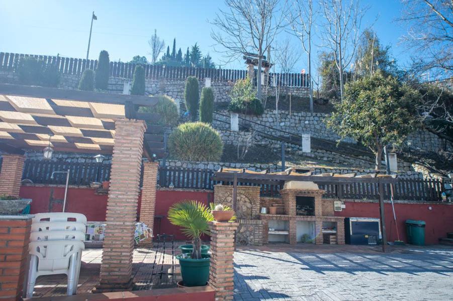 a backyard with a brick patio with a fireplace at Las Huertas in Monachil