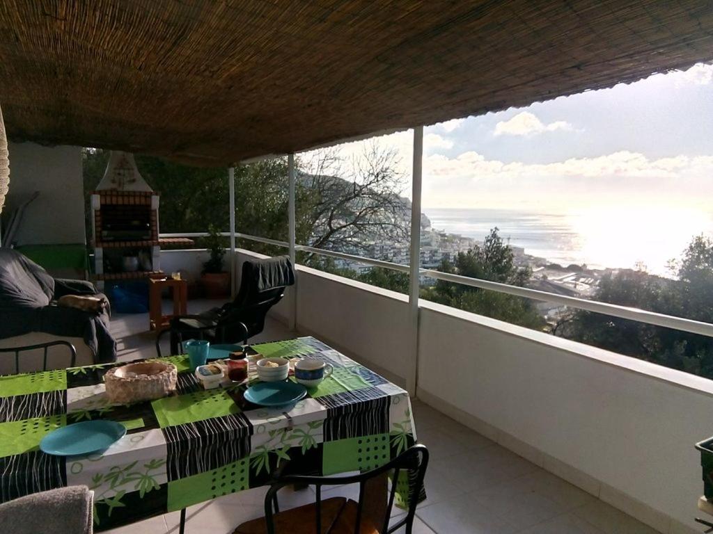 un balcone con tavolo e vista sull'oceano di Casa do avô Teixeira a Sesimbra