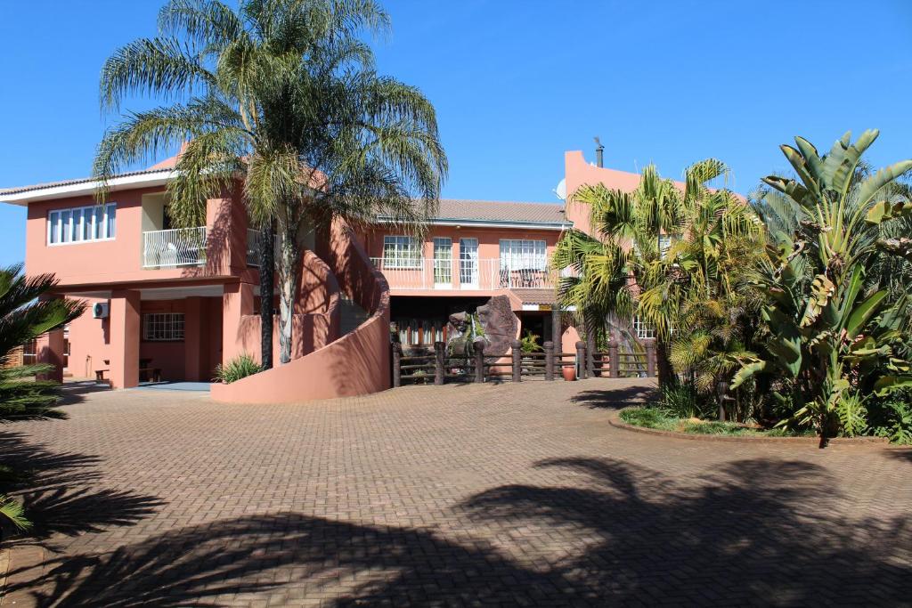 a building with palm trees in front of it at El Gran Chaparral Guest House in Pretoria