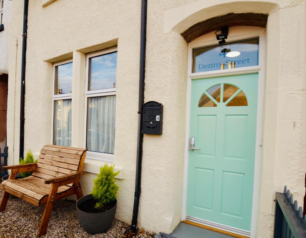 une porte bleue sur un bâtiment avec un banc dans l'établissement The Stags Head Apartment, à Inverness