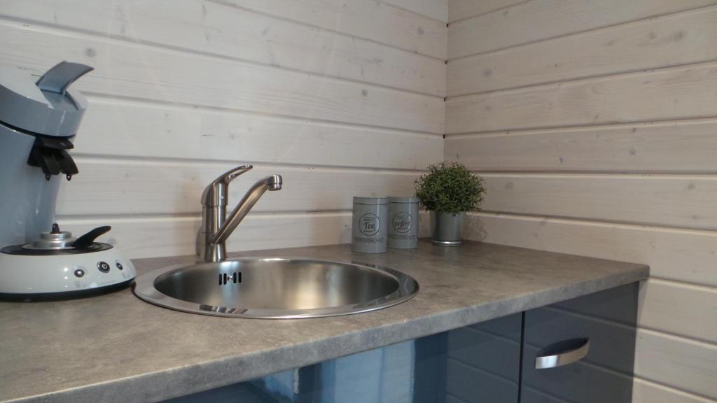 a kitchen counter with a stainless steel sink at Au Cap Norwoe in Saint-Quentin-en-Tourmont