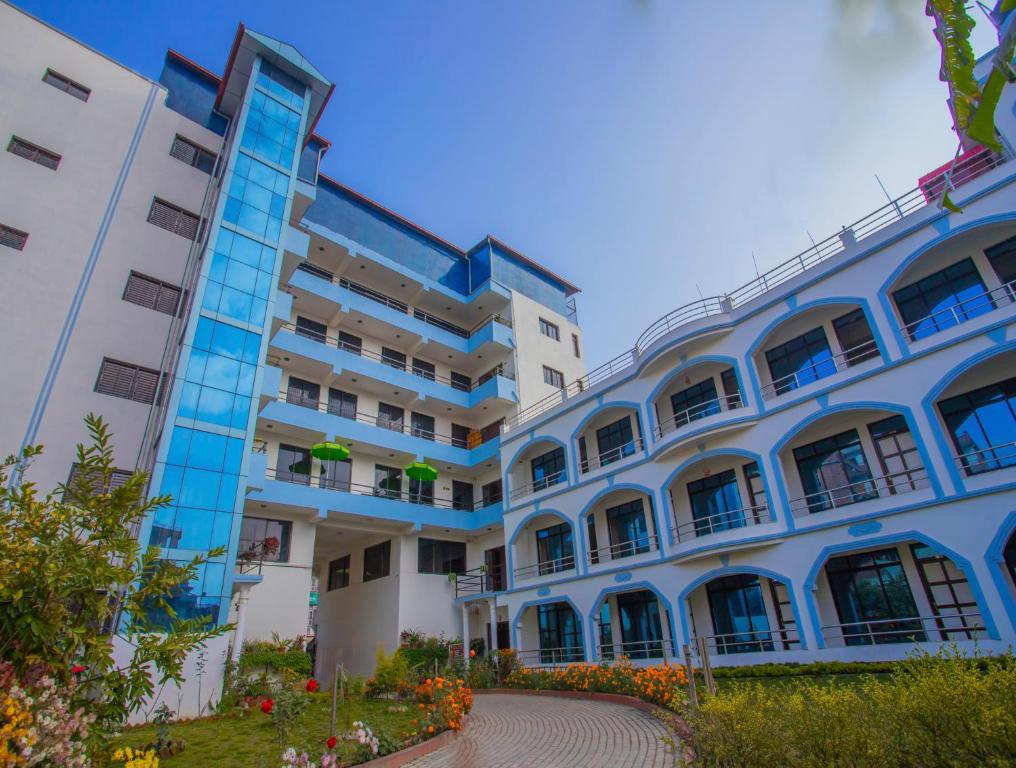 a blue and white building with flowers in front of it at Hotel Satyam in Banepa